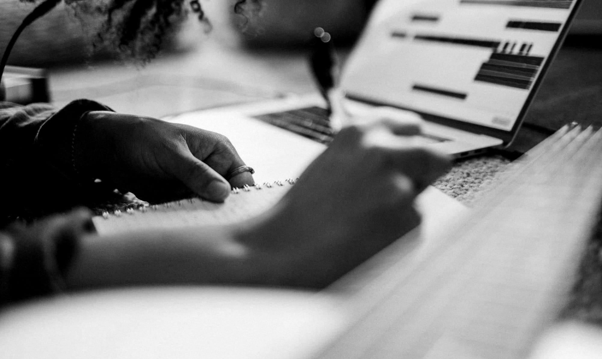 woman in black and white shirt writing on white paper